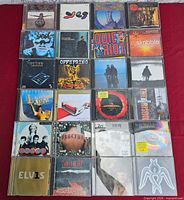 Full grid view of all 25 CDs on red surface