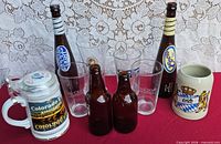 All items arranged together for overview: two tall bottles, two small bottles, four pint glasses, two ceramic steins
