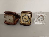 Front view of all three clocks showing dials and cases