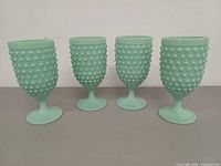 Front view of all four jadeite hobnail goblets