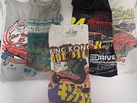 All five graphic t-shirts folded showing front graphics