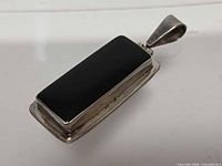 Front angled view of rectangular onyx pendant in sterling setting