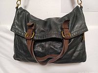 Front view folded showing brown buckle straps and handles