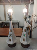 Both lamps lit without shades showing ceramic bodies and jewel accents