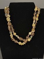 Necklace displayed on black bust form showing overall design and color mix