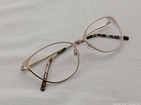 Front angled view of gold-tone Vera Wang V595 eyeglass frames showing full-rim design and temple tips