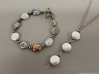 Bracelet and necklace laid out showing pearls, bead spacers and clasps