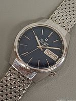 Front view showing blue dial, day-date window, hands and indices