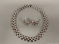 Necklace and earrings laid flat showing overall design and condition