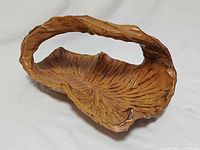 Front angled view showing overall shape, handle and interior leaf pattern