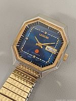 Front view showing blue dial, gold bezel, day-date