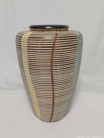 Front view of ribbed ceramic vase with color stripes