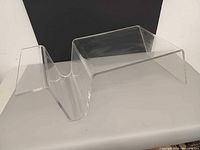 front perspective of clear lucite end table showing magazine holder and tabletop