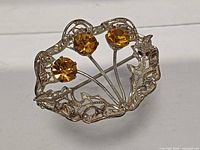 front view showing three amber stones and filigree silver frame