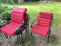 Four red cushioned chairs, three stacked, one separate