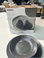 Box of Stokes 12-piece dinnerware with example dinner plate in front