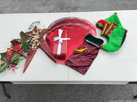 All items grouped on table: placemats, tree topper, tin, pouch, elf shoes