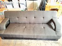 Front view of gray charcoal tufted sofa with arms