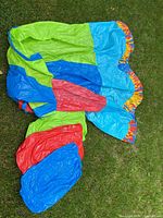 Deflated multicolour vinyl slide and attached pieces on grass