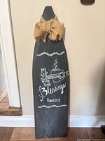Front view of charcoal wooden decorative sign with burlap bow and painted scripture