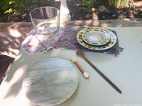 Group shot of marble board, trifle bowl, stacked floral plates, spoon, spatula