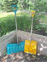Full view of both snow pushers leaning outdoors