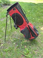 Full side view of red/black stand golf bag with legs extended