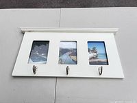 Front view showing three photo openings and three metal hooks