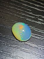 Top view of oval opal showing play of colour