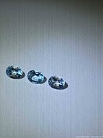 Trio of oval blue topaz gemstones on neutral background