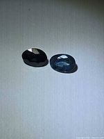 Both oval sapphires side by side showing color variation