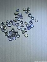 Loose multicoloured round Tanzanite gemstones spread on surface