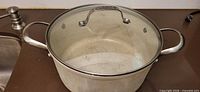 Speckled enamel stock pot with lid on countertop
