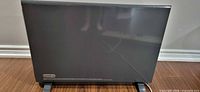 Front view of dark gray DeLonghi Slim Style panel heater on floor stand
