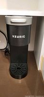 Front view of Keurig compact slim coffee maker showing full unit and drip tray