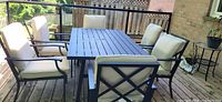 full view of table with six cushioned chairs on deck