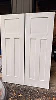 Front view of both closet doors showing panel design and white finish