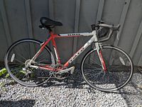 Full left-side view of red and white Toto Apache road bike
