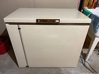 Front view of beige Kenmore chest freezer with closed lid