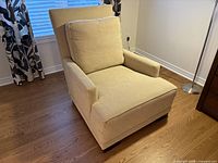 Front angle of beige lounge chair showing cushions and arms