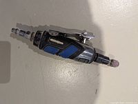 Side view of Mastercraft air rotary tool showing lever trigger, blue grip, attached air fitting and grinding stone
