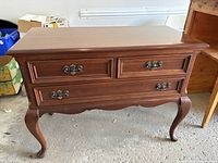 Front view of solid wood sideboard showing three drawers and cabriole legs