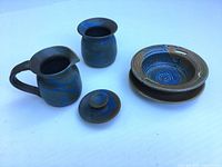 Overall view of four pieces – creamer, sugar bowl with lid, serving dish, hardwood bowl