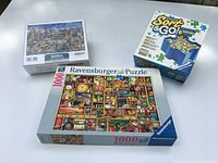 Three boxed items: sealed World Architecture puzzle, opened Ravensburger puzzle, Sort & Go stacking trays