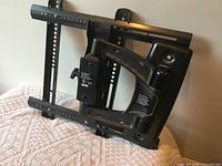 Front view of metal TV wall mount showing arm and rails