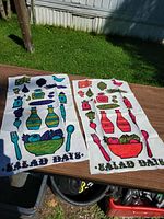 Both tea towels laid flat showing full graphics and text