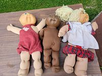 All three dolls laid out on table showing full bodies