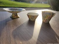 pedestal bowl, sugar bowl, creamer on table in sunlight