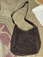 Front view of brown suede Cabrelli purse showing overall shape and strap
