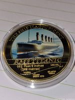 Obverse showing enameled image of RMS Titanic, text THE SHIP MAGNIFICENT and specifications